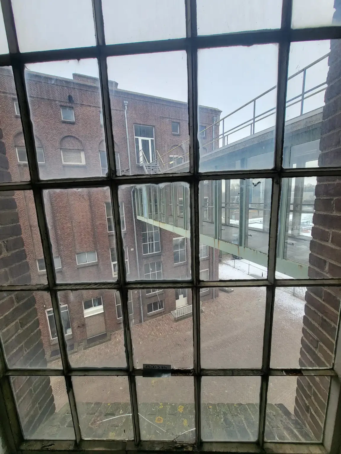 Foto door het raam van de oude Dongecentrale richting het kantoorpand waar Stichting Uniek ook zit.